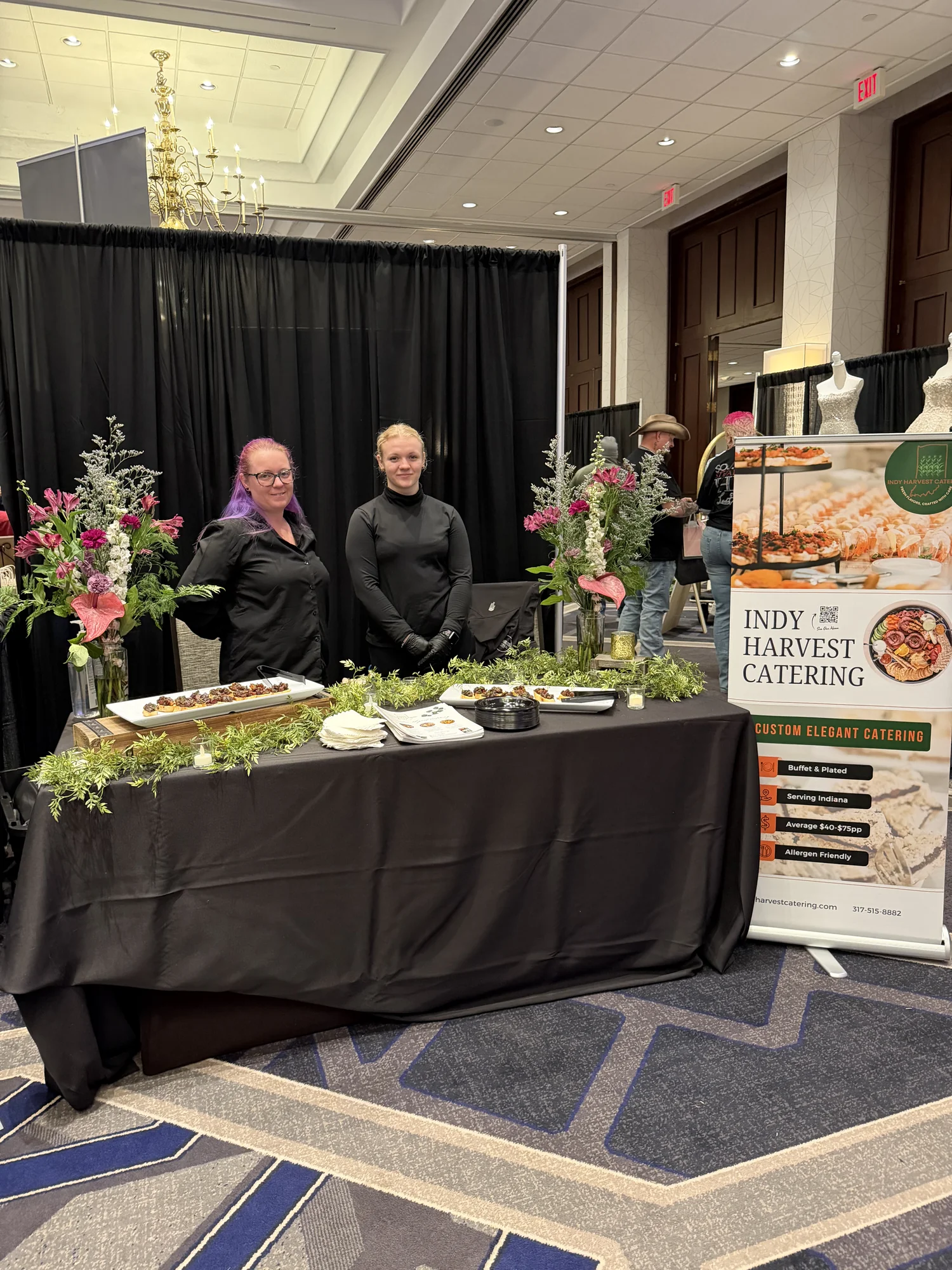 Indy Harvest Catering booth with florals and tasting plates
