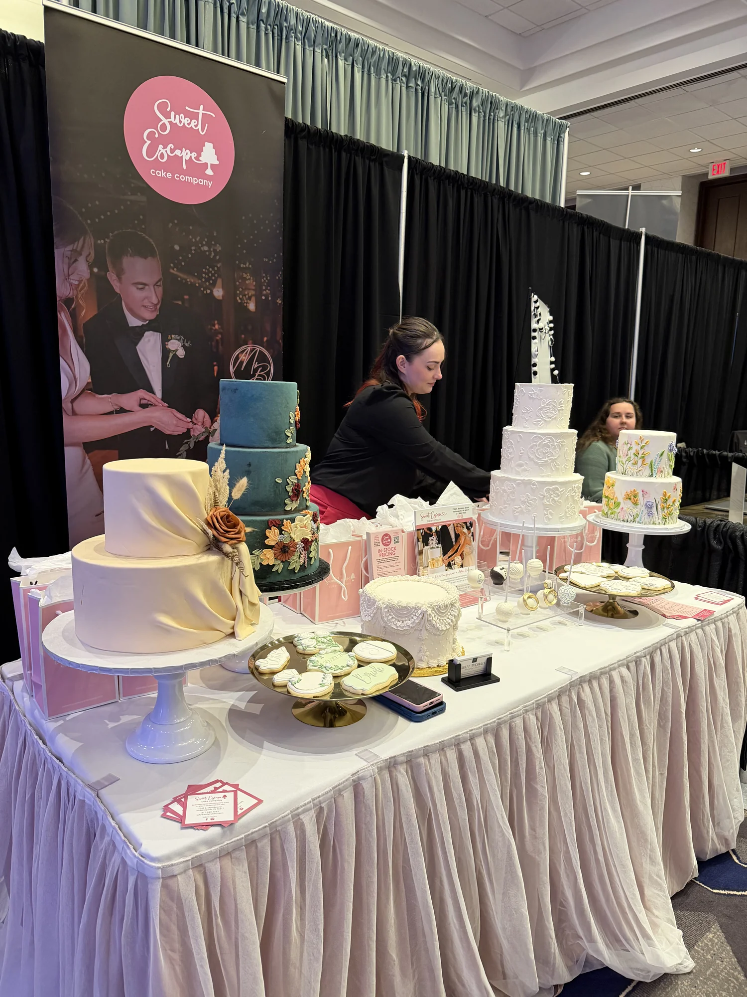 Sweet Escape cake booth with tiered cakes and cookies